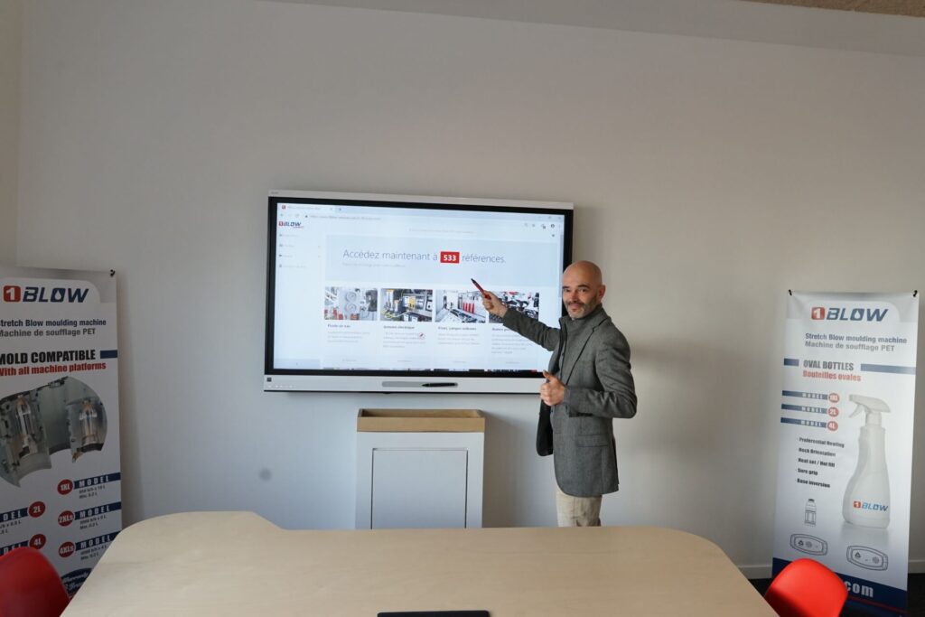 Benoit Sánchez, director general de 1 BLOW, señala una gran pantalla en la que se ve el sitio web.