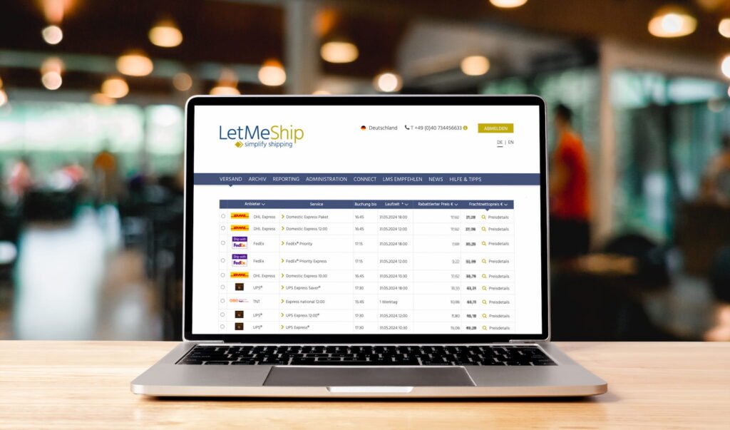 Ordenador portátil abierto mostrando la interfaz de reservas de LetMeShips con comparación de precios y transportistas.