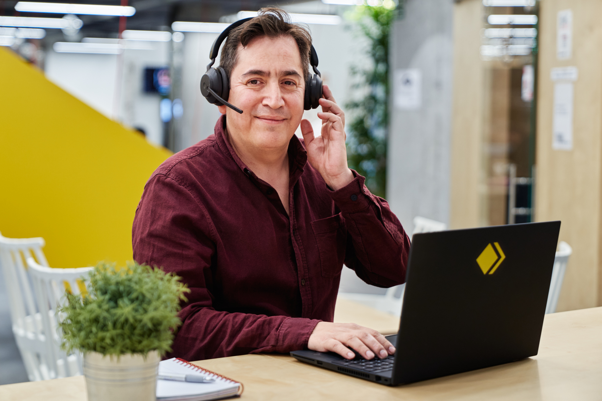 Gustavo con auriculares en su mostrador de atención al cliente en Madrid.